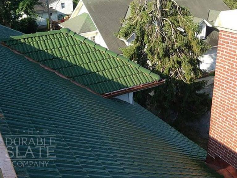 green clay tile roof in st paris ohio with evergreens in the background