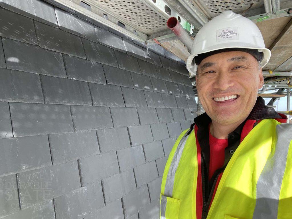 a man wearing a hat and smiling at the camera