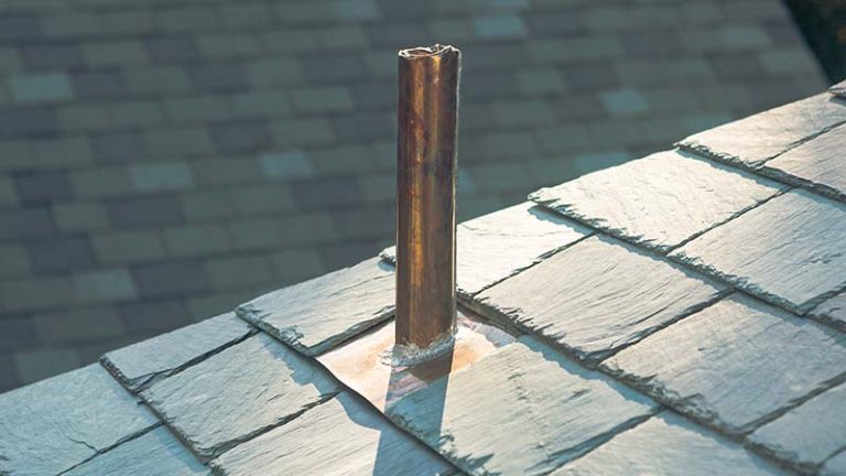 close up of a copper vent pipe, vent flashing, and slate roof