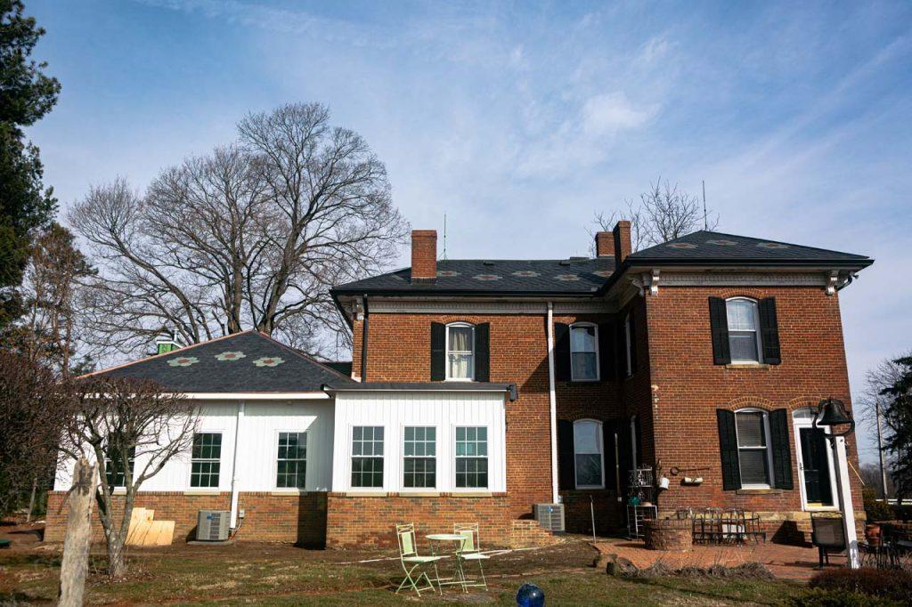 a large brick building with grass in front of a house