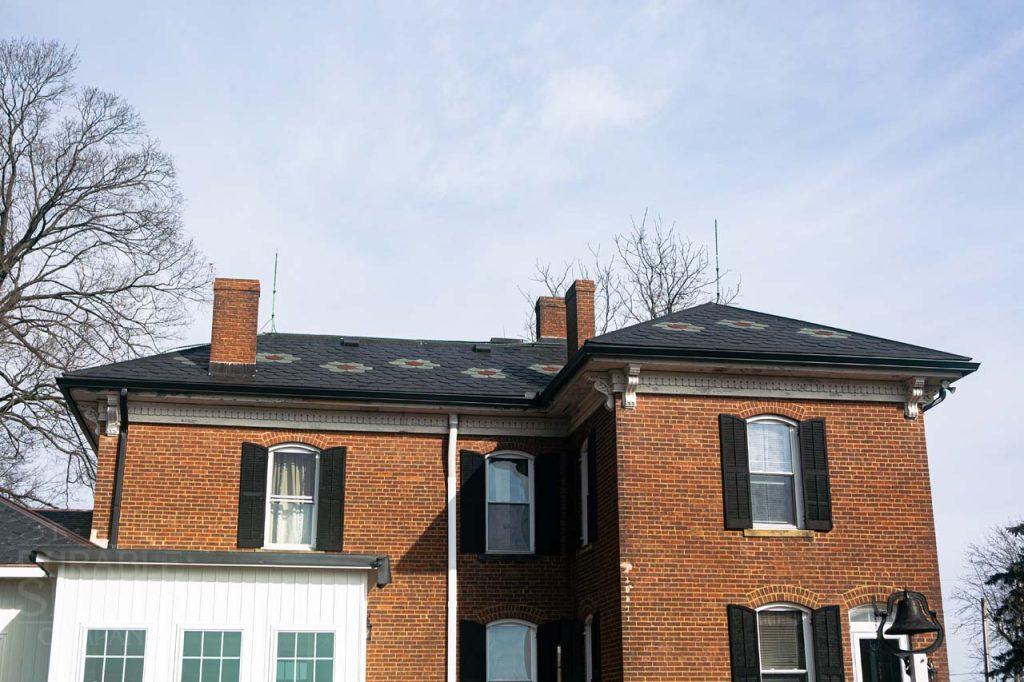 a large brick building with a sign in front of a house