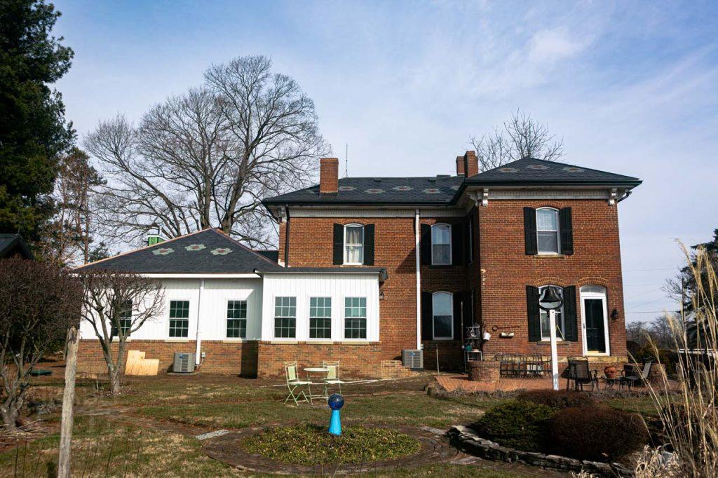 a large brick building with grass in front of a house