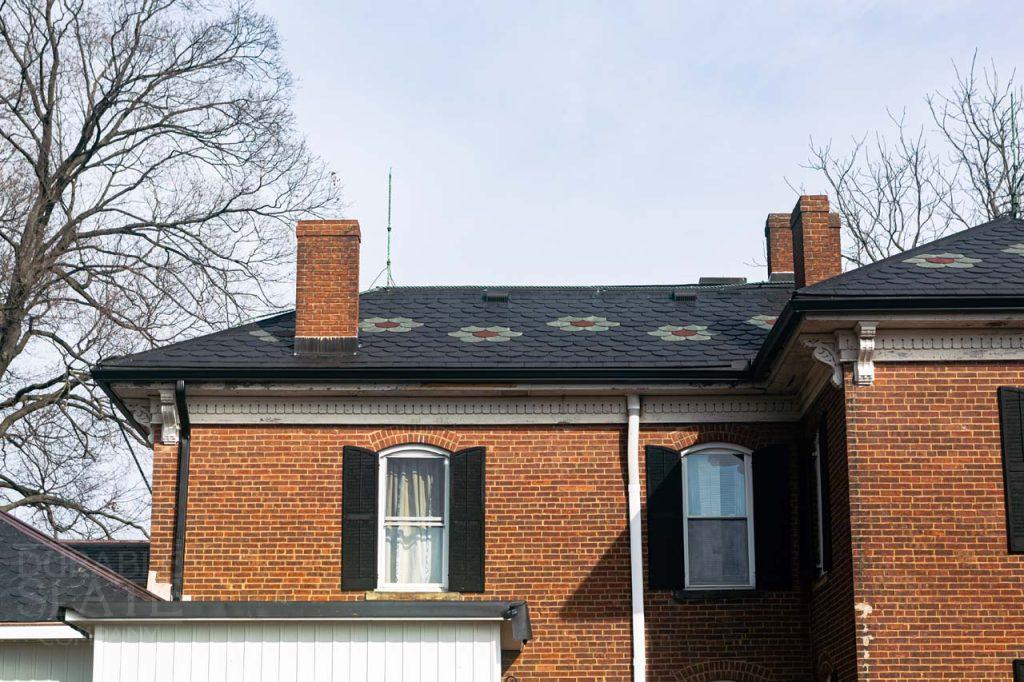 a large brick building with a clock on the front of a house