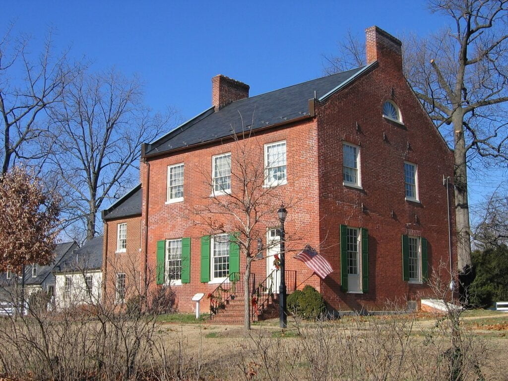 a large brick building with grass in front of a house