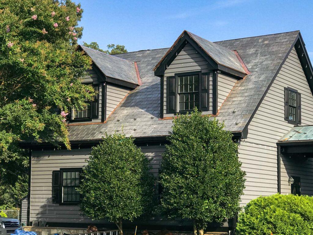 an old brick house with trees in the background