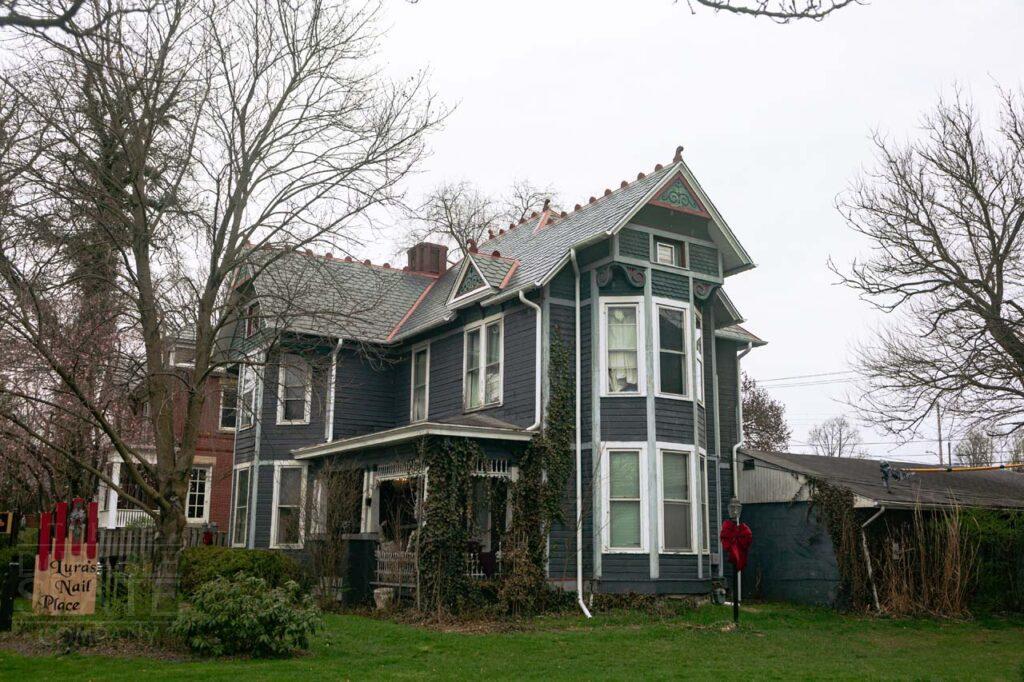 a large brick building with grass in front of a house