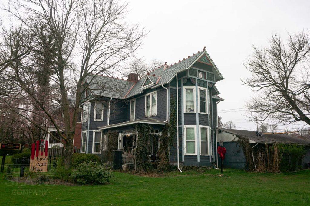 a large brick building with grass in front of a house