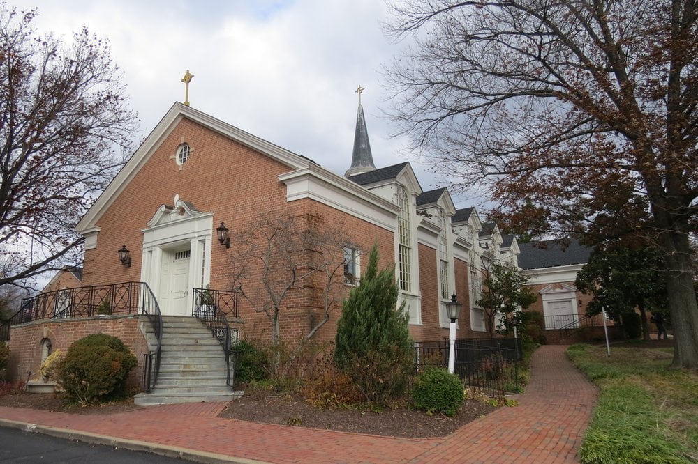 a large brick building with grass in front of a house