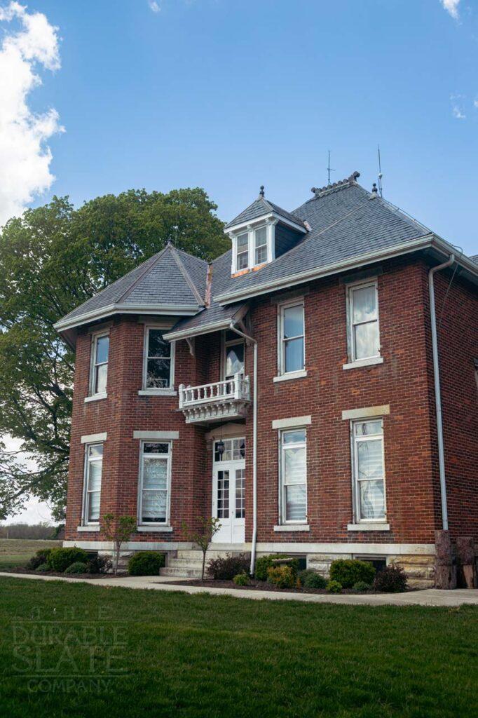 a large brick building with grass in front of a house